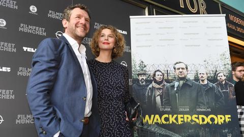 29.06.2018, Bayern, München: Die Schauspieler Johannes Zeiler (l) und Anna Maria Sturm sind bei der Weltpremiere des Politdramas "Wackersdorf" vor dem Filmtheater Sendlinger Tor vor dem Filmplakat zu sehen.