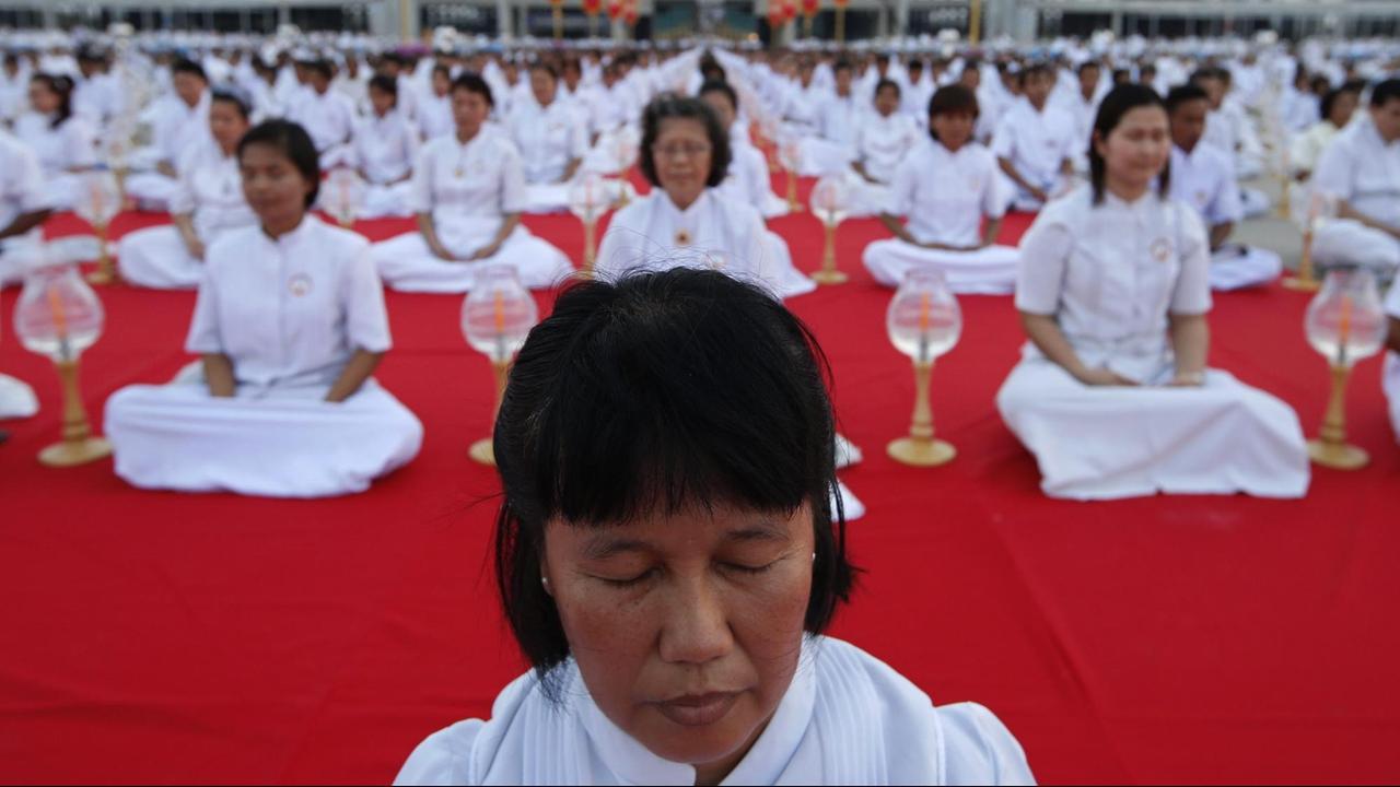 Buddhistische Gläubige meditieren vor dem Dhammakaya Tempel - ganz in weiß
