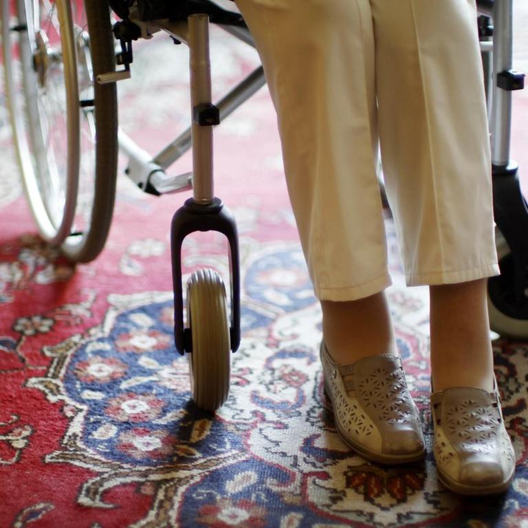 Die Beine einer 97-jährigen Seniorin, die in einem Rollstuhl sitzt.
