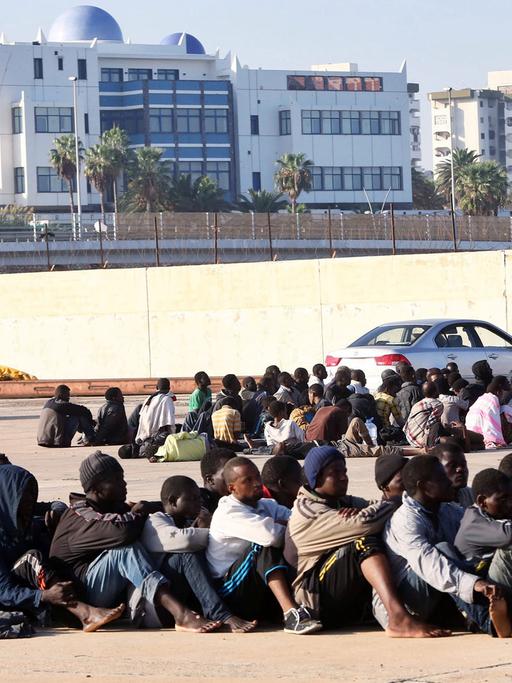 Flüchtlinge, die von der libyschen Marine nördlich von Tripoli festgenommen wurden, warten am 5.10.2015 in einem Dock im Hafen der Hauptstadt Libyens.