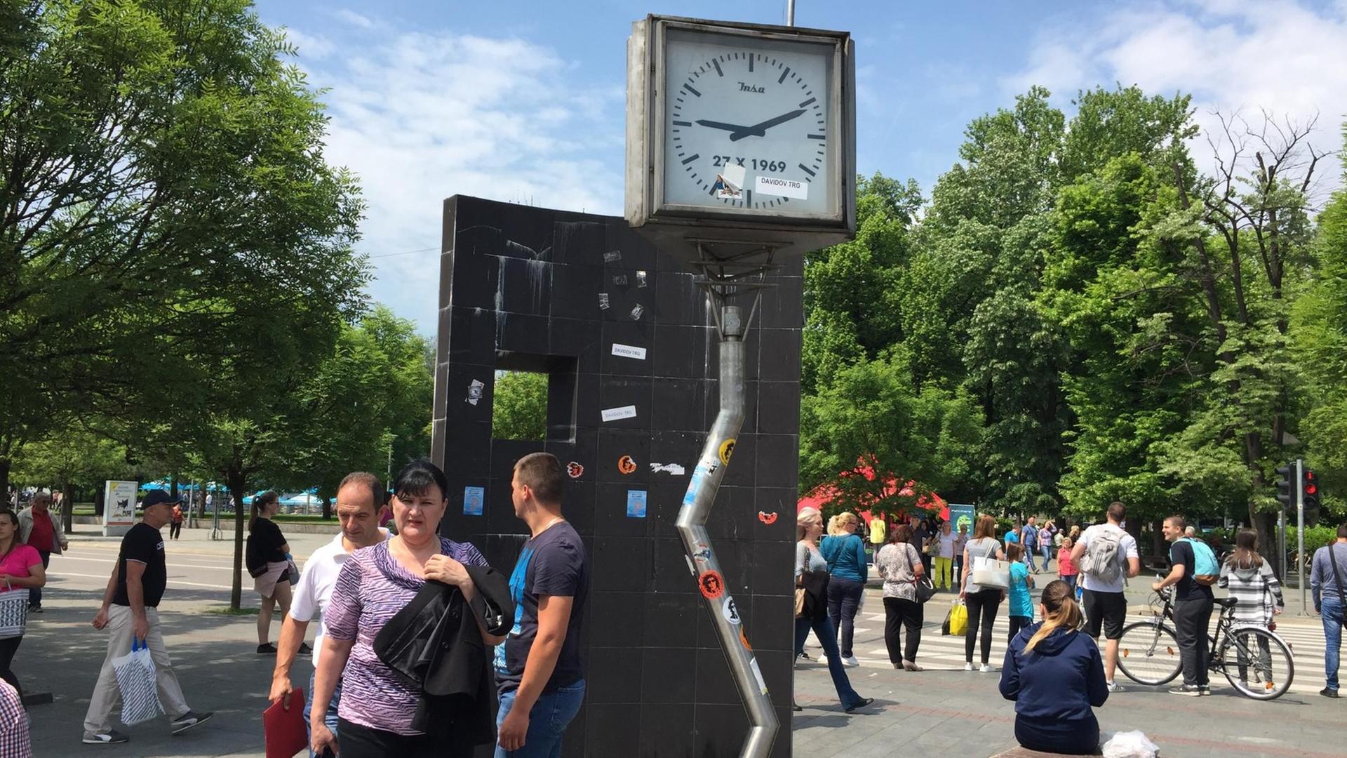 Kaputte Uhr auf eingeknicktem Pfosten