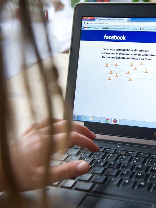 Ein Kind surft an einem Laptop auf der Seite des sozialen Netzwerks "Facebook".