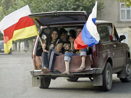 Südossetien: Bewohner halten die russiche und die südossetische Flagge