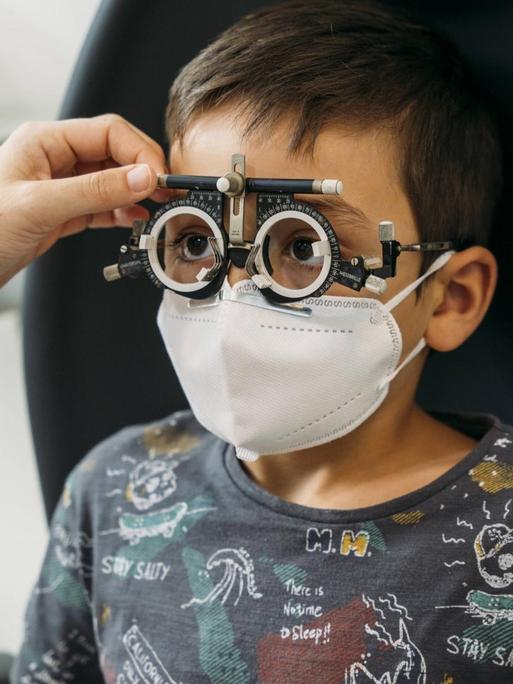 Ein Kind wird bei einem Augenarzt untersucht.