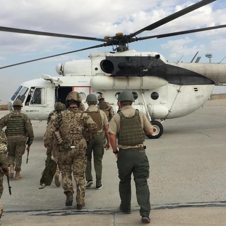 Mehrere Bundeswehrsoldaten gehen auf einen Hubschrauber zu