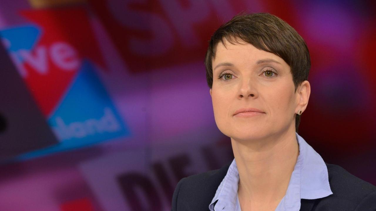 Frauke Petry, die Chefin der AfD. Auf der Wand hinter ihr stehen die Logos der großen deutschen Parteien.