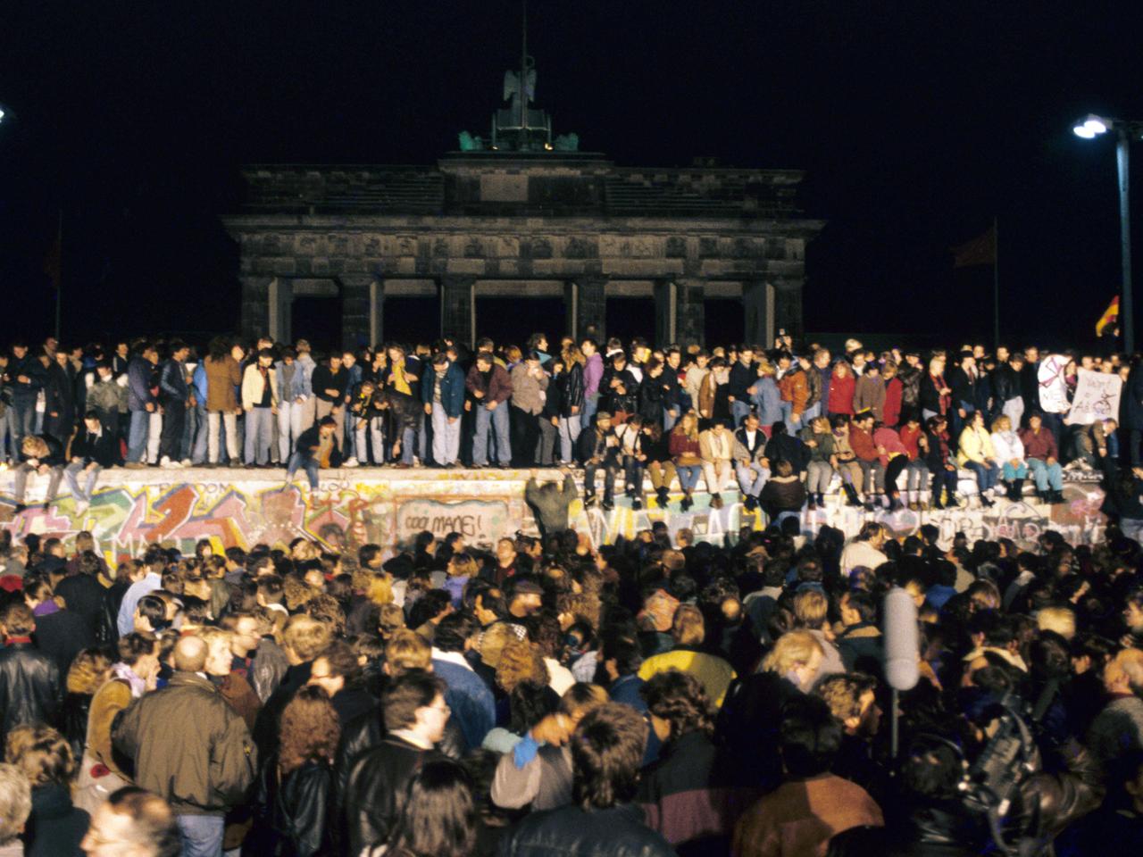 	Eine große Menschenmenge versammelte sich am Abend des 10. November 1989 vor und auf der Mauer am Brandenburger Tor in Berlin.
