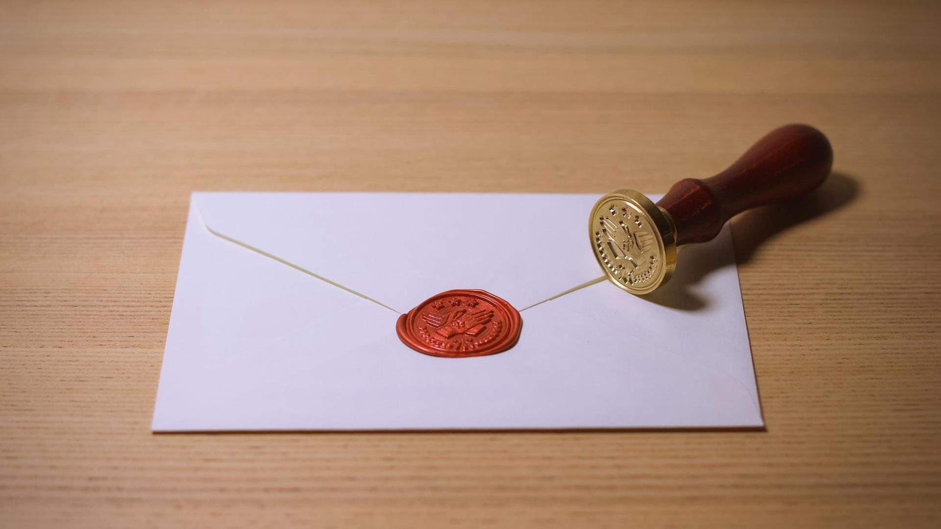 Ein Briefumschlag mit rotem Siegel und einem Stempel daneben.