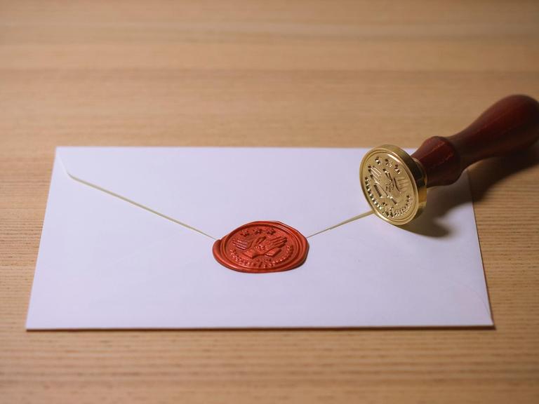 Ein Briefumschlag mit rotem Siegel und einem Stempel daneben.