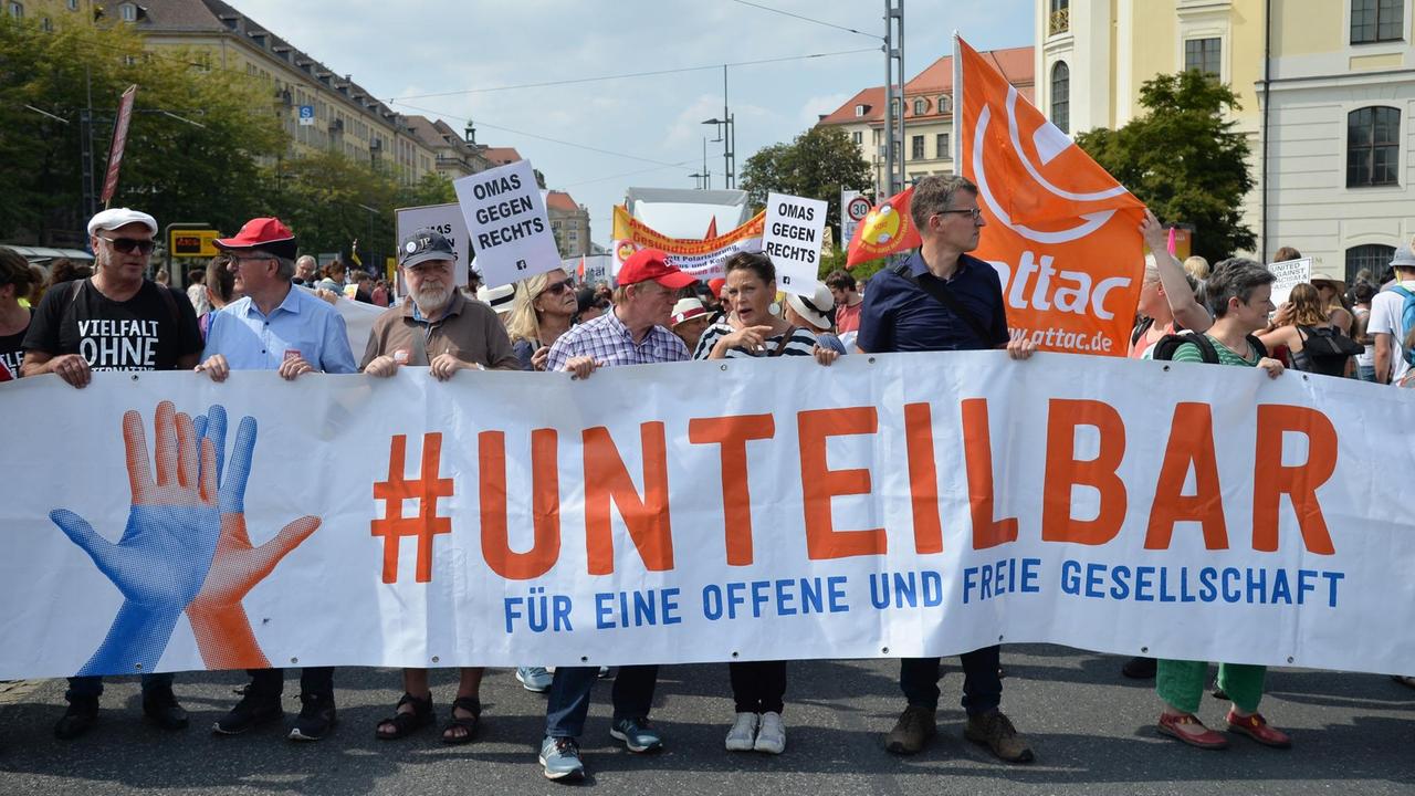 Demonstranten tragen ein Transparent mit dem Schriftzug #Unteilbar bei der gleichnamigen Demo am 24. August 2019 in Dresden.