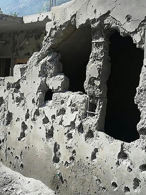 Ein Bewohner in der Region Kashmir steht vor sienem zerstörtem Haus.