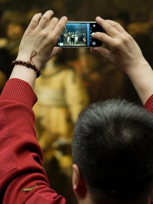 Besucher des Reichsmuseums in Amsterdam fotografieren Rembrandts "Nachtwache"
