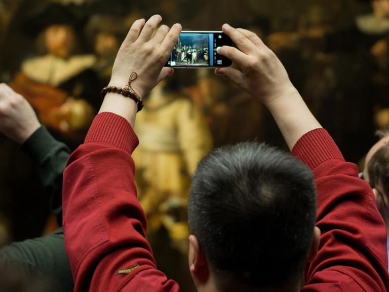 Besucher des Reichsmuseums in Amsterdam fotografieren Rembrandts "Nachtwache"