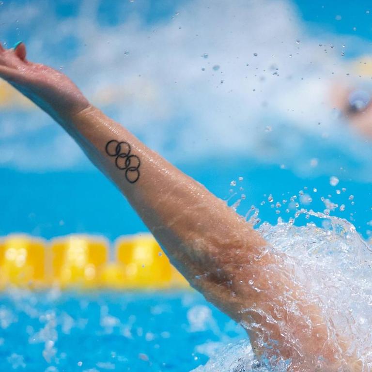 Die Olympischen Ringe zieren in Form eines Tatoos den Arm eines Rückenschwimmers