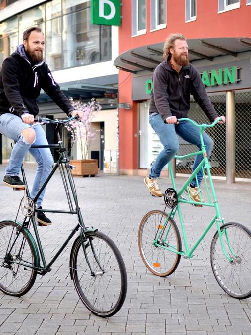 Zwei Männer fahren mit ihren Hochrädern durch die nahezu menschenleere Innenstadt in Oldenburg.