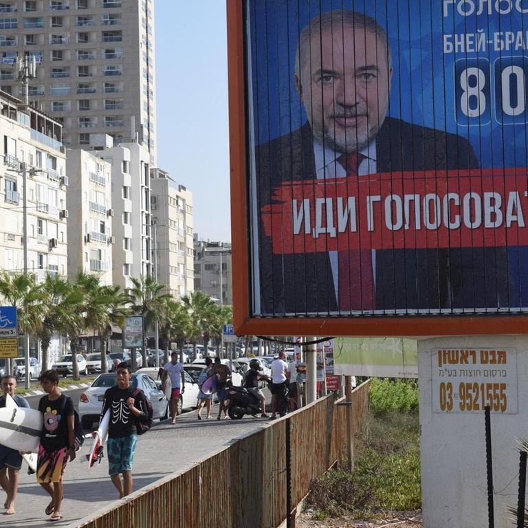 Israelis laufen an einem Wahlplakat des Vertreters der russischstämmigen Juden, Avigdor Lieberman, vorbei, aufgenommen im September 2019