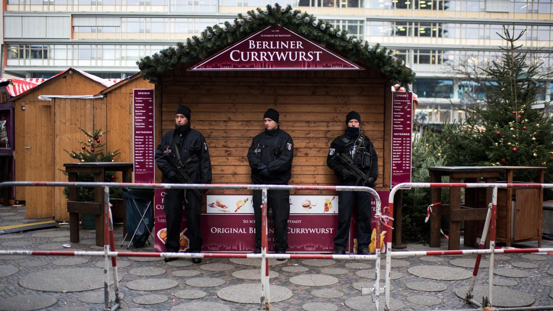 Polizisten stehen nach dem Anschlag auf dem Berliner Weihnachtsmarkt am Breitscheidplatz Wache.