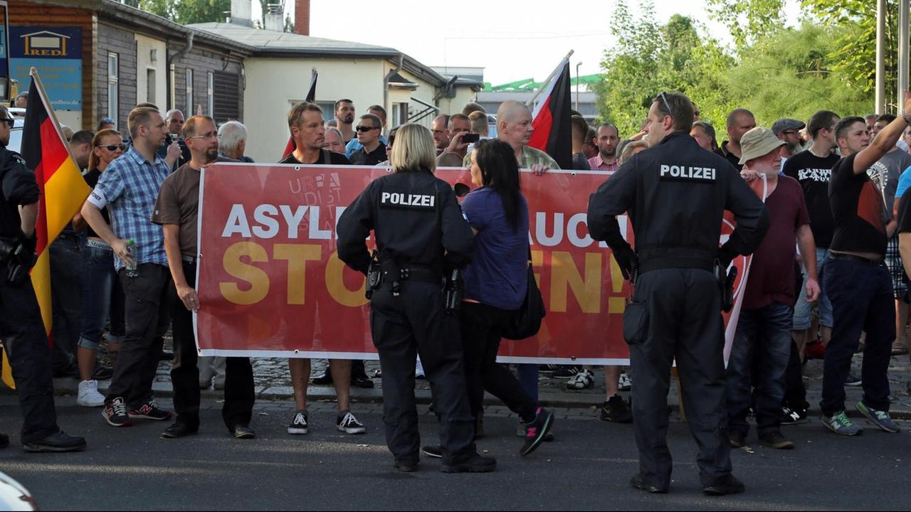 Zu sehen sind Menschen, die im Juli 2015 in Dresden gegen ein Zeltlager für Flüchtlinge demonstrieren