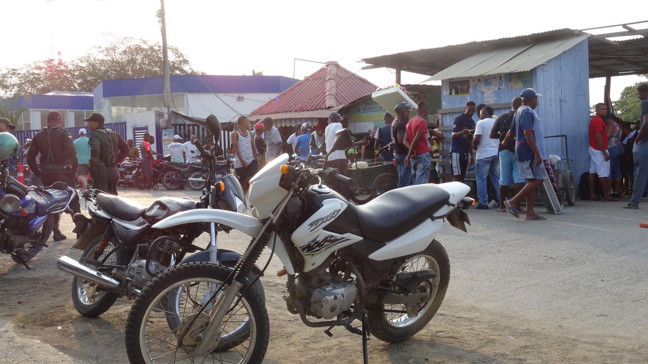 Motorräder, Menschen, Buden, Handkarren und Polizei sind zu sehen in Turbo, dem wichtigsten Hafen am Golf von Urabá in Kolumbien und Umschlagsort für Kokain.