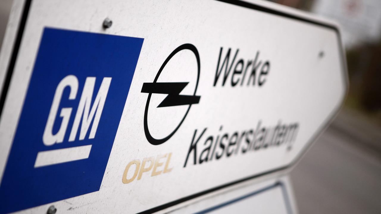 Ein Schild mit dem General Motors- und dem Opel-Logo weist den Weg zum Opel-Werk in Kaiserslautern.