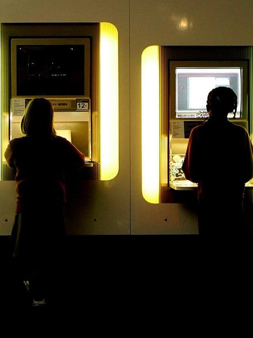 Kinder spielen am Computer im Science Museum London und sind von hinten zu sehen.