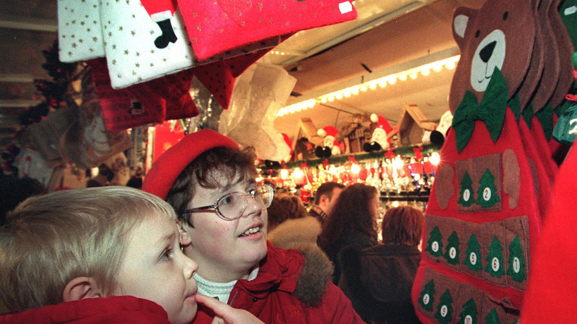 FRANCE, Strasbourg : Une maman choisit avec son enfant, le 27 novembre 1999, un calendrier de l'Avent en forme de Père Noël au premier jour du célèbre marché de Noël.