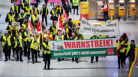 Mitarbeiter des Sicherheitspersonals nehmen in Terminal 1 am Frankfurter Flughafen an einem Warnstreik teil.