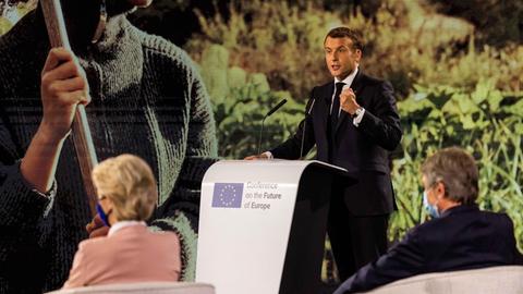 Emmanuel Macron (M, En Marche), Staatspräsident von Frankreich, spricht während der Eröffnungsveranstaltung der Konferenz zur Zukunft Europas im Gebäude des Europäischen Parlaments während Ursula von der Leyen (l, CDU, Fraktion EVP), Präsidentin der Europäischen Kommission, und David Sassoli (r, PD, Fraktion S&D), Präsident des Europäischen Parlaments, im Vordergrund sitzen.