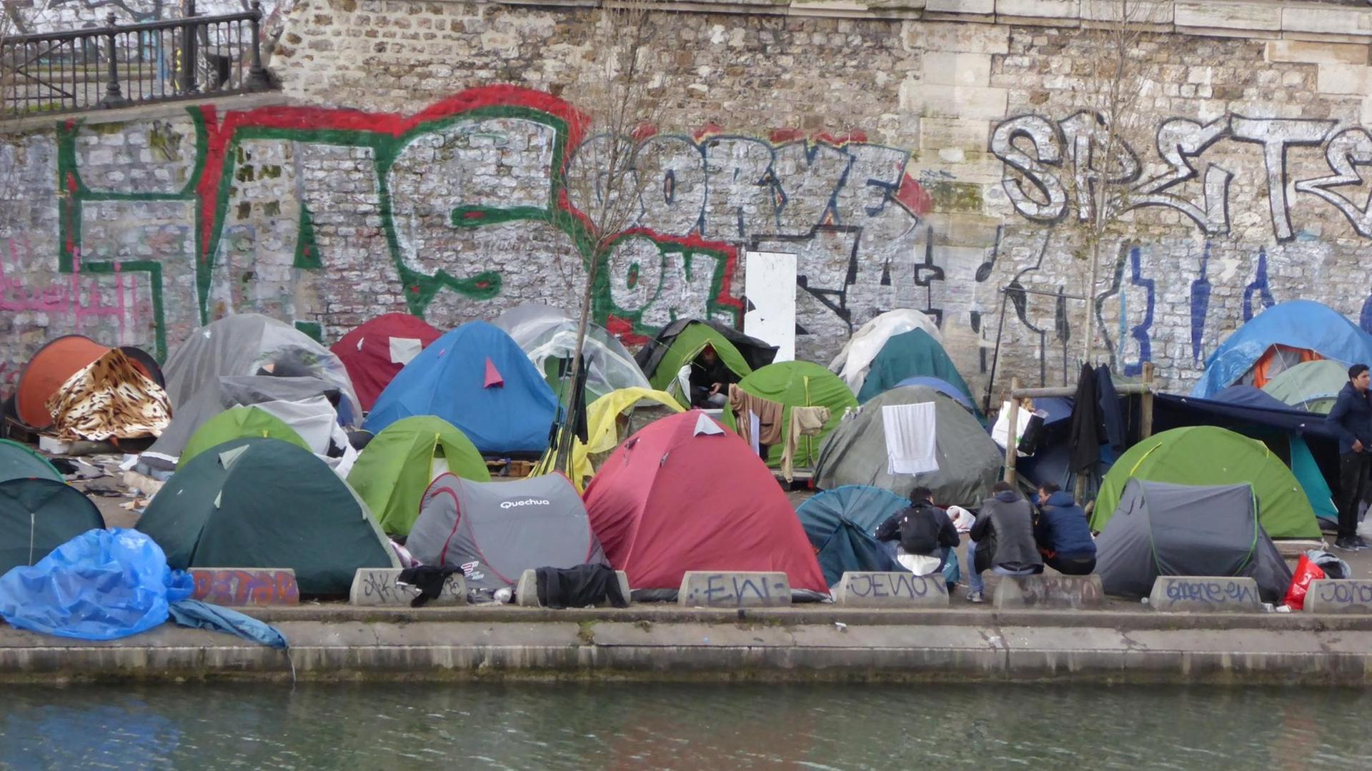 Blick vom anderen Seine-Ufer auf zahlreiche bunte Zelte an einer Ufermauer am Kai. Blick vom anderen Seine-Ufer auf zahlreiche bunte Zelte an einer Ufermauer am Kai.