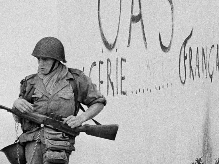 Ein Soldat vor einer Hauswand.