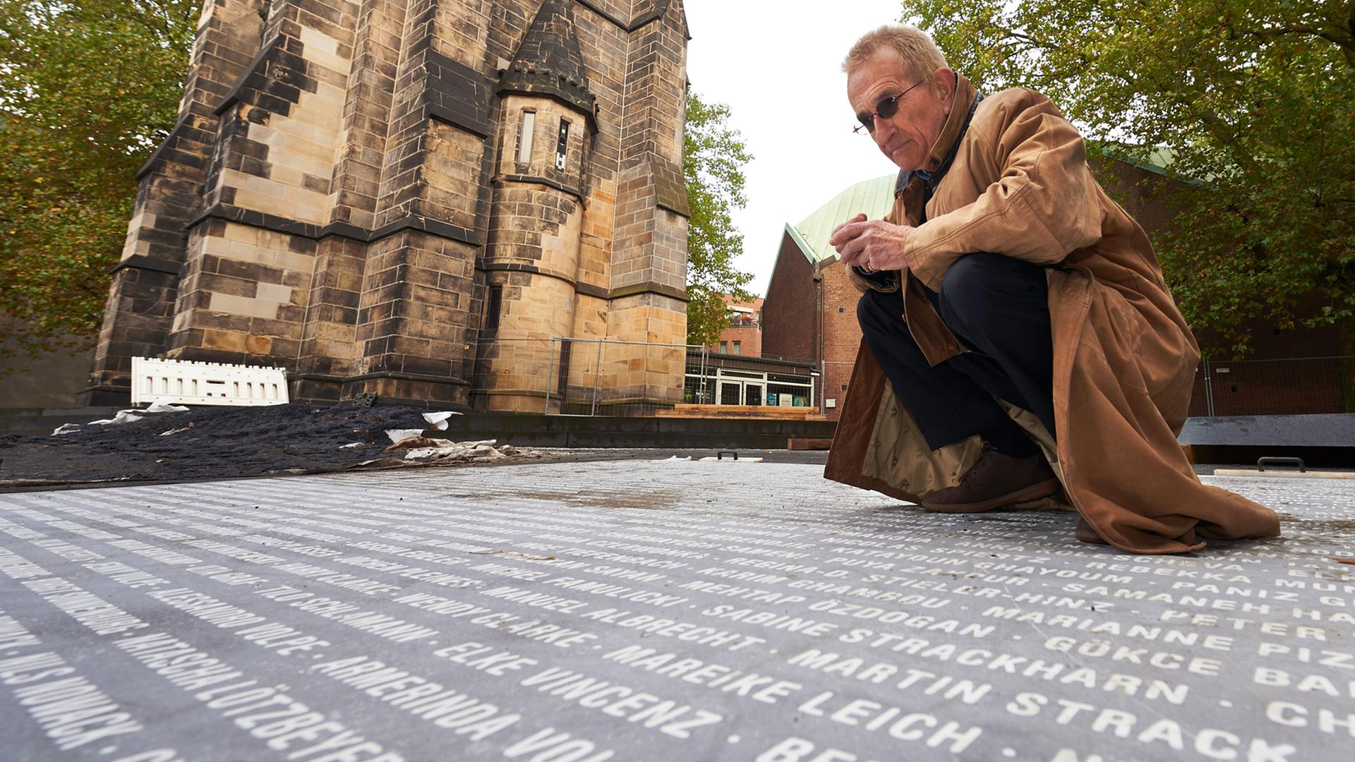 Jochen Gerz untersucht kurz vor der Eröffnung (11.12.2015) sein Werk "Platz des europäischen Versprechens" in Bochum vor der Christuskirche. 14.726 Namen von Bürgern sind dort eingraviert.