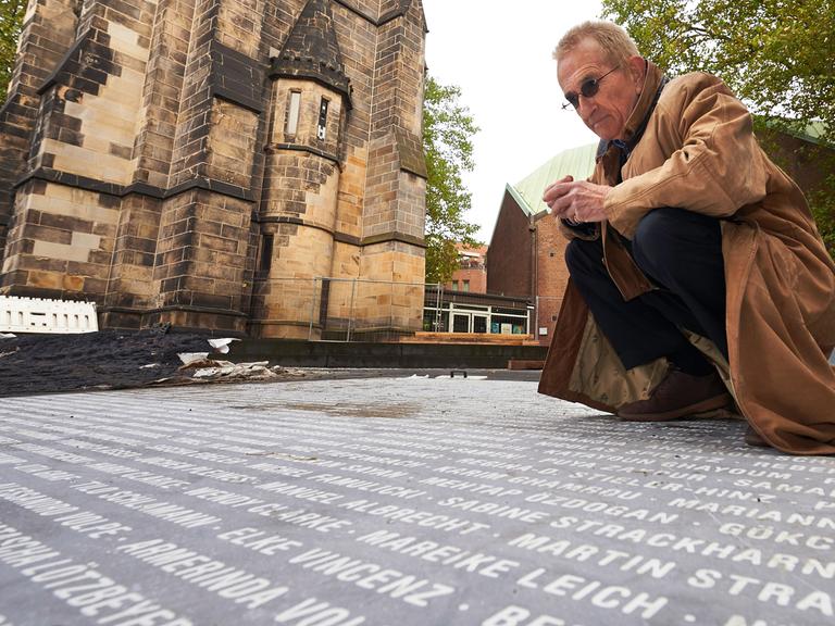 Jochen Gerz untersucht kurz vor der Eröffnung (11.12.2015) sein Werk "Platz des europäischen Versprechens" in Bochum vor der Christuskirche. 14.726 Namen von Bürgern sind dort eingraviert.