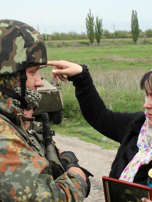 Eine Bürgerin diskutiert im ukrainischen Slawjansk mit einem Soldaten.
