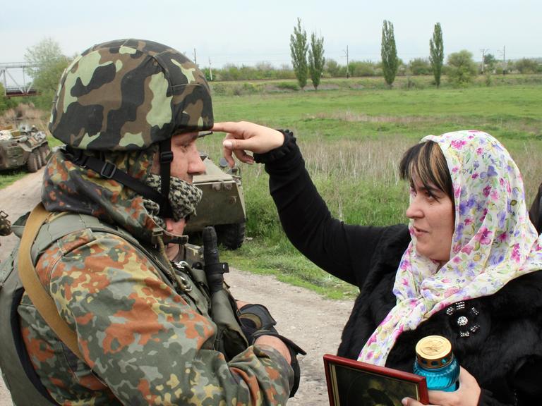 Eine Bürgerin diskutiert im ukrainischen Slawjansk mit einem Soldaten.