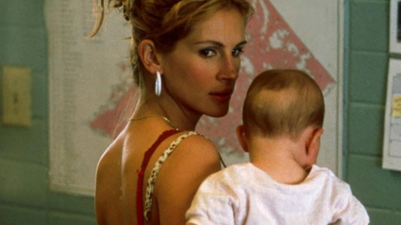 Julia Roberts trägt ein Baby auf dem Arm und blickt entschlossen über dessen Schulter.
