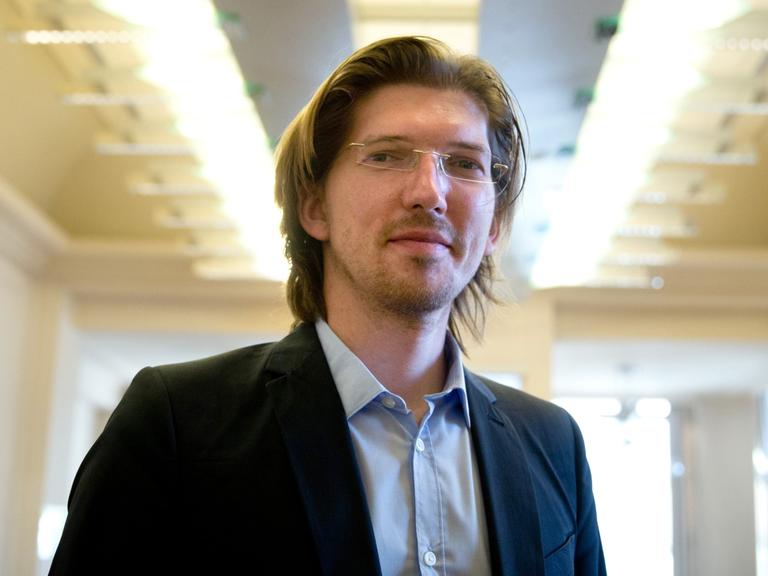 Der Vorsitzende des Untersuchungsausschusses des Berliner Abgeordnetenhauses zum Flughafen BER, Martin Delius (Piraten), blickt am 14.03.2014 im Abgeordnetenhaus in Berlin zu Beginn der Sitzung des Ausschusses in die Kamera des Fotografen. Foto: Kay Nietfeld/dpa