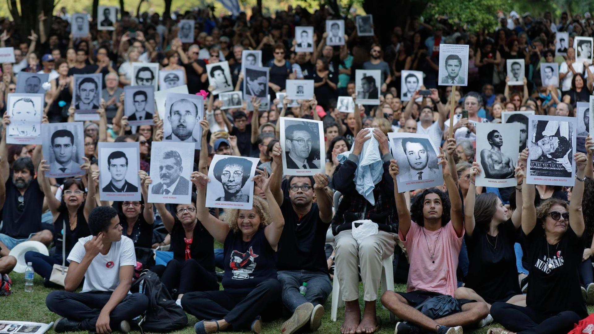 Eine Gruppe Demonstranten mit Fotos von Menschen, die während der Militärdiktatur in Brasilien verschwanden oder umgebracht wurden.