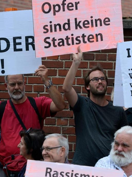 Teilnehmer einer Schweigeminute erinnern 2019 mit Plakaten auf der Kölner Keupstrasse am 15. Jahrestag an den NSU-Nagelbombenanschlag, bei dem dort 22 Menschen verletzt wurden, vier davon schwer. Am 9. Juni 2004 hatten