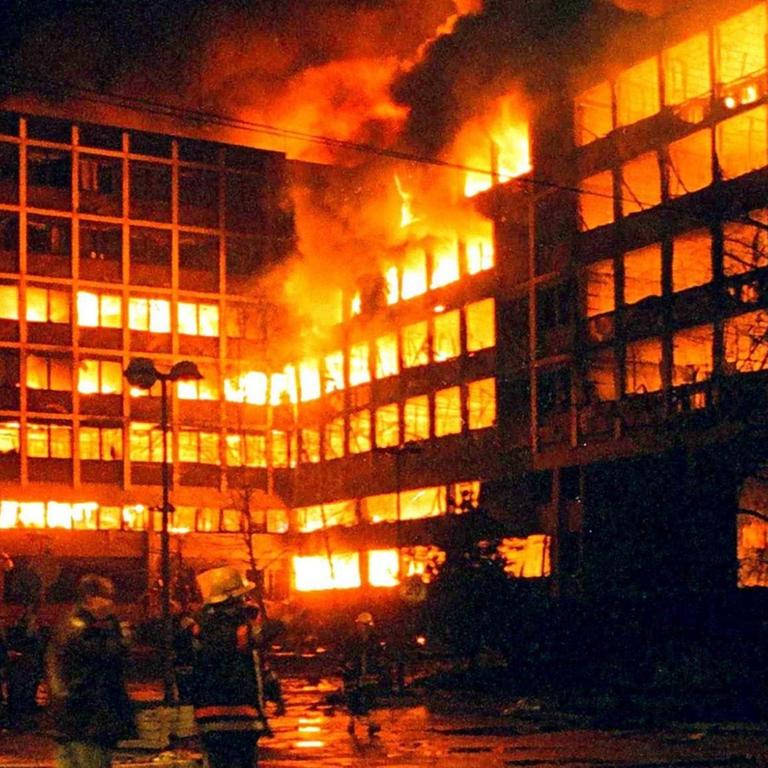 Belgrader Feuerwehrleute am 3.4.1999 vor dem brennenden serbischen Innenministerium in Belgrad. Mehrere Marschflugkörper schlugen gegen 1.00 Uhr morgens in den benachbarten Gebäude des serbischen und des jugoslawischen Innenministeriums ein. Augenzeugen berichteten von fünf gewaltigen Explosionen im dichtbesiedelten Stadtteil um die verkehrswichtige Knez-Milosa-Straße. Die Fensterscheiben der umliegenden Wohnhäuser seien zerborsten. Die beiden getroffenen Ministerien liegen unmittelbar neben einem großen Krankenhauskomplex. Die Nato hatte erstmals seit Beginn der Offensive vor zehn Tagen das Zentrum Belgrads beschossen.