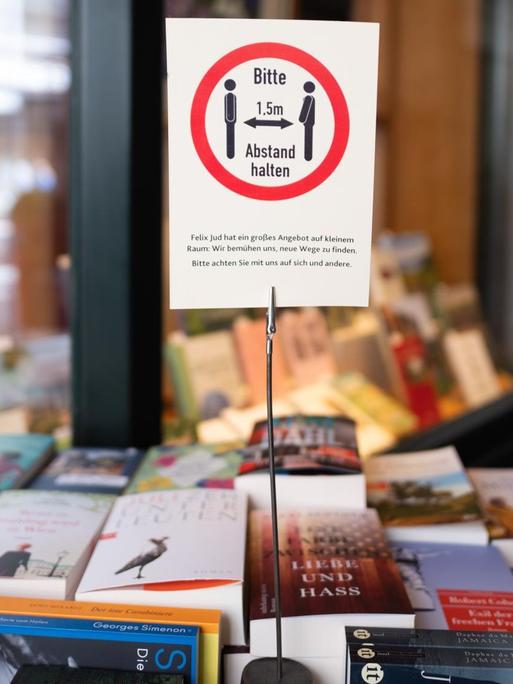 Ein Schild mit einem Hinweis auf die Abstandsregeln steht vor einer Buchhandlung in Hamburg.