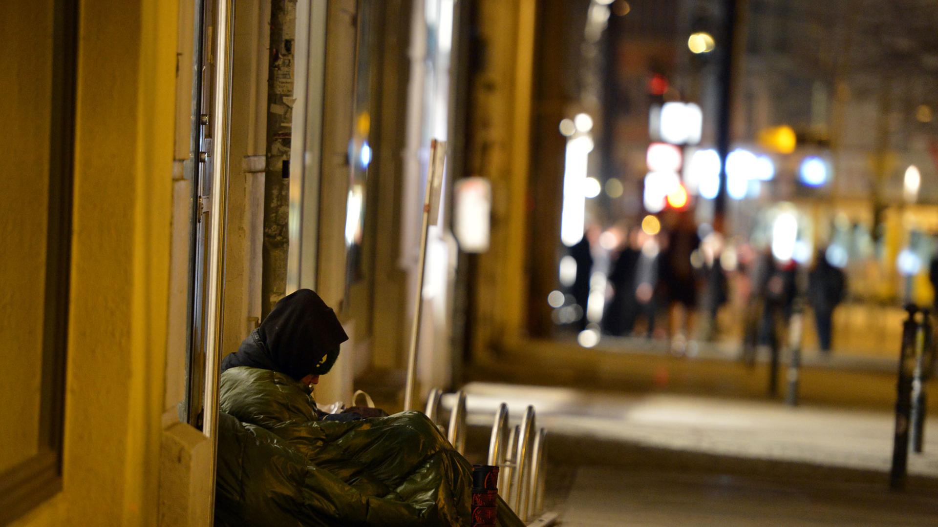 Ein Obdachloser sitzt im Februar 2014 in Berlin Mitte auf dem Gehweg.