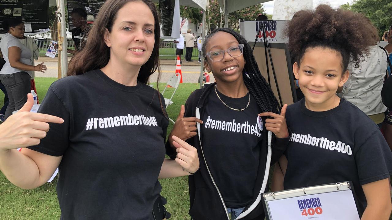 Drei weibliche Jugendliche tragen schwarze T-Shirts mit der Aufschrift #rememberthe400 in Fort Monroe. Damit erinnern sie an die Ankunft der ersten Sklaven in Virginia im Jahr 1619 - vor 400 Jahren also.