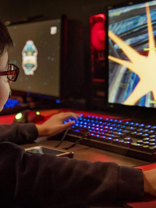 Ein kleiner Junge spielt Fortnite am Computer.