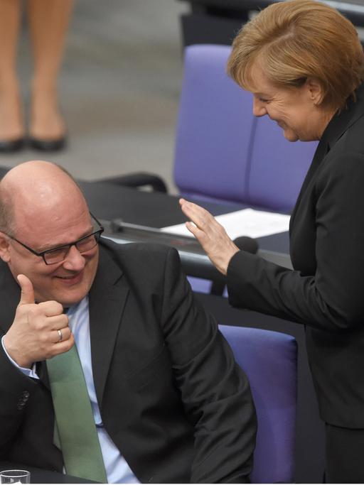 Bundeskanzlerin Angela Merkel (CDU, r) und Steffen Kampeter (CDU), Staatssekretär im Bundesfinanzministerium, im Bundestag. Beide lachen.
