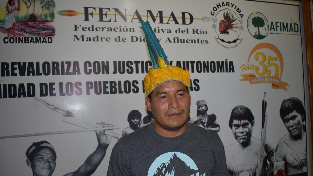 Eusebio Rios, der Vizepräsident des Indigenenverbands FENAMAD, der die sieben indigenen Völker der Amazonasregion Madre de Dios vertritt. Er trägt T-Shirt und eine traditionelle Kopfbedeckung