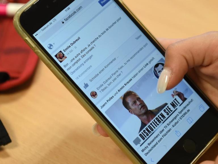 Eine Frauenhand nutzt ein Smartphone.