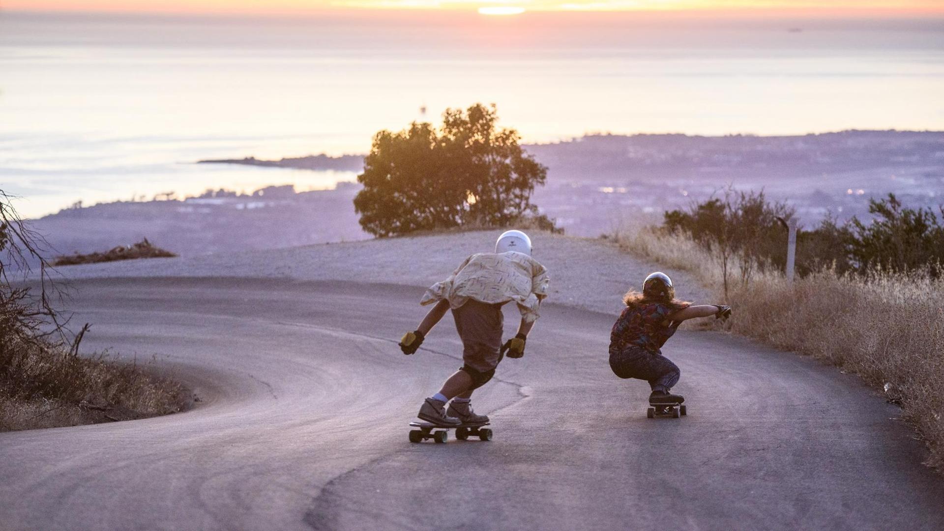 Zwei Skater fahren in Kalifornien eine Straße hinunter.