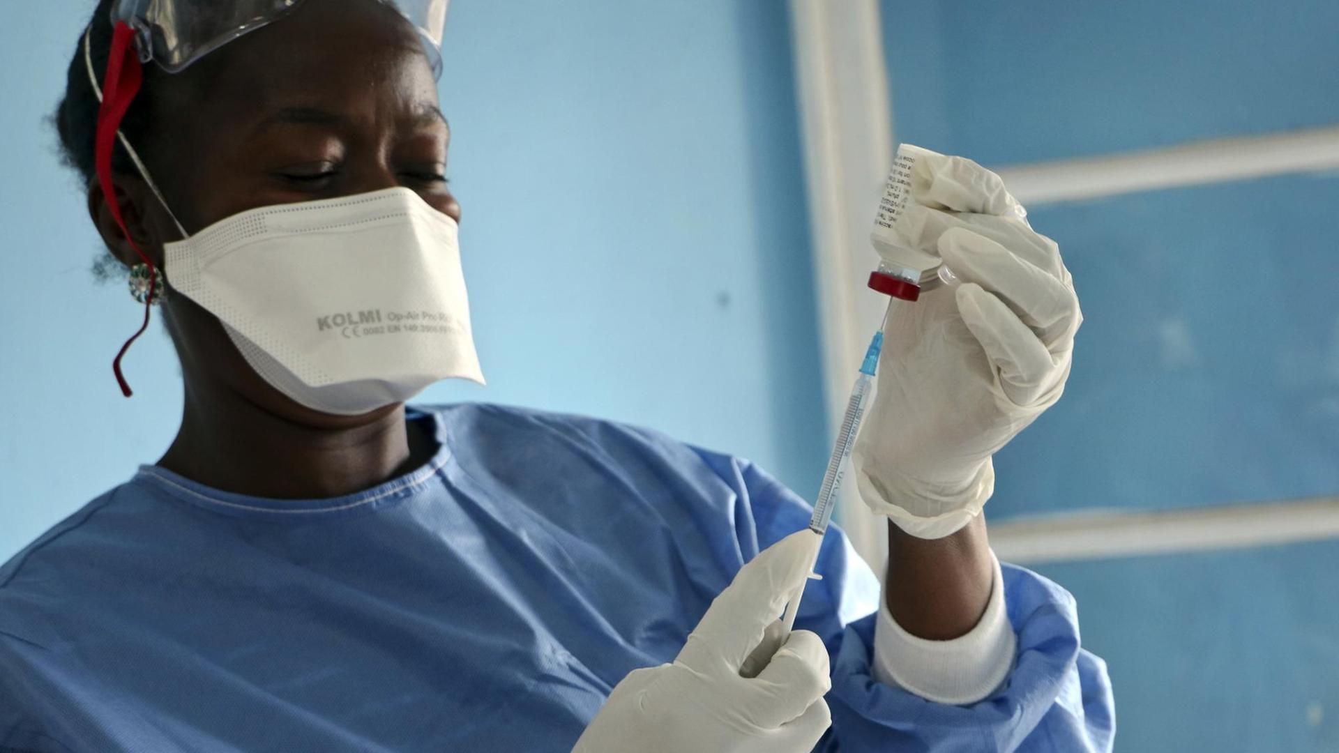 Medizinisches Personal beim Aufziehen einer Spritze für eine Impfung gegen Ebola im Kongo