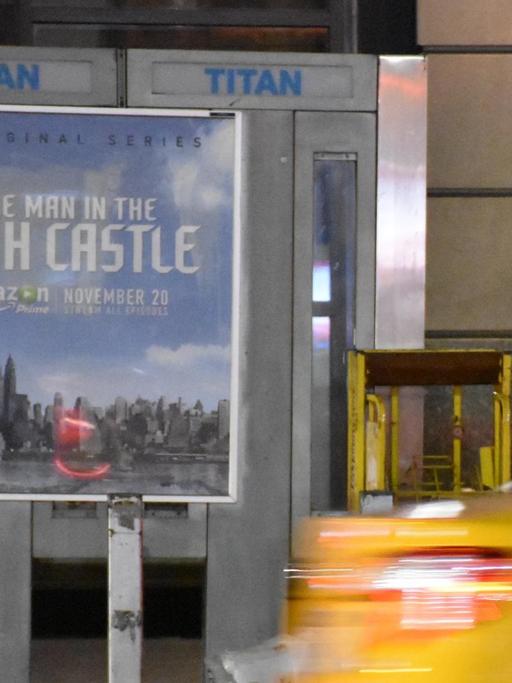 Eine Taxi fährt in New York an der Werbung für die TV-Serie "The Man in the High Castle" vorbei. Das Plakat zeigt die New Yorker Freiheitsstatue mit Hitlergruß und roter Nazischärpe.