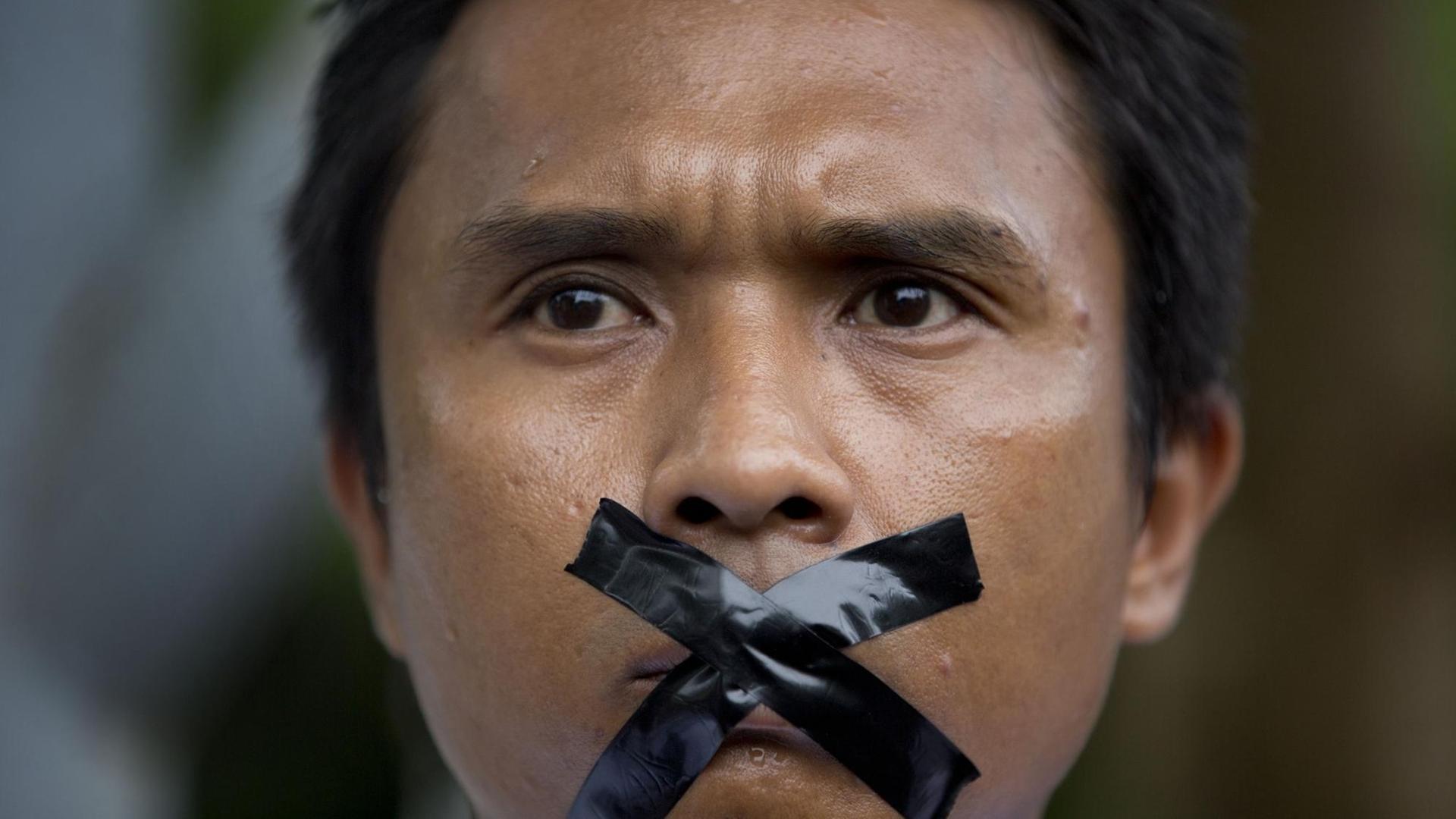 Ein Journalist aus Myanmar hat sich aus Protest gegen Zensur den Mund mit Klebeband verklebt.